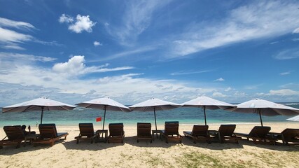 A beach with lounge chairs and umbrellas on it at Pandawa beach, Bali