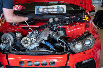 Detail of a third generation red car in the workshop, it has a swap to a 5-cylinder engine