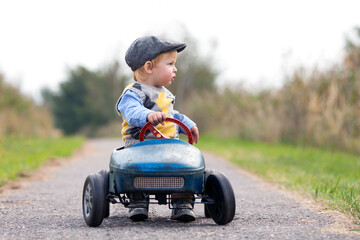 kleiner Junge unterwegs im Tretauto