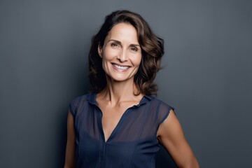Obraz premium Cheerful Mature Woman Smiling Against Grey Wall. Photo generative AI
