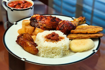 A plate of Colombian food, including rice, chicken, pies