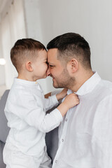 Fototapeta premium Dad plays with his little son on the sofa. Family pastime. Happy smiling people. 