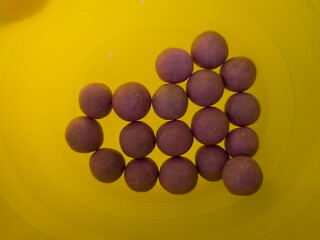 cherry dragee heart on yellow background