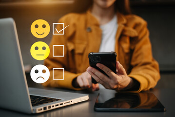 Customer service evaluation concept. woman Show face smile emoticon show on virtual screen from hand.looking at smart phone, tablet and laptop - obrazy, fototapety, plakaty