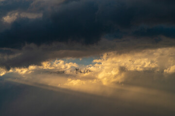 Beautiful dramatic sky with sunbeams through the clouds at sunset