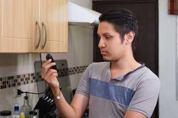 Young diabetic man holding blood sugar meter. Checking Blood Sugar Level At Home. Diabetic Checking Blood Sugar Levels. Checking blood sugar level by glucometer and test stripe at home