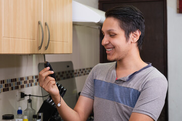 Young diabetic man holding blood sugar meter. Checking Blood Sugar Level At Home. Diabetic Checking Blood Sugar Levels. Checking blood sugar level by glucometer and test stripe at home