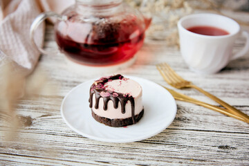 No sugar raspberry vegan dessert with carob and teapot and cup of natural tea. Healthy breakfast