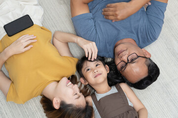 View of happy asian family lying on the floor.