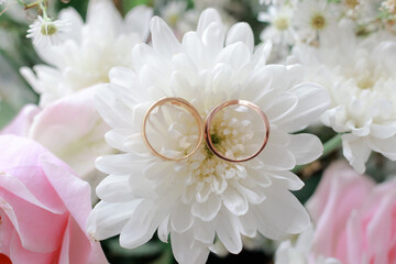 Wedding rings on white flowers.