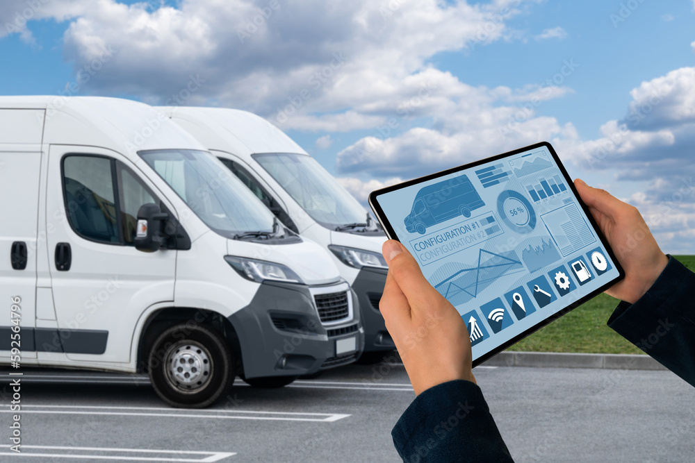 Poster Manager with a digital tablet on the background of vans. Fleet management
