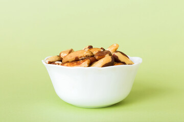 Fresh healthy Brazil nuts in bowl on colored table background. Top view Healthy eating bertholletia concept. Super foods