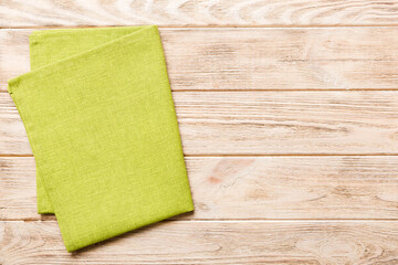 top view with green kitchen napkin isolated on table background. Folded cloth for mockup with copy space, Flat lay. Minimal style