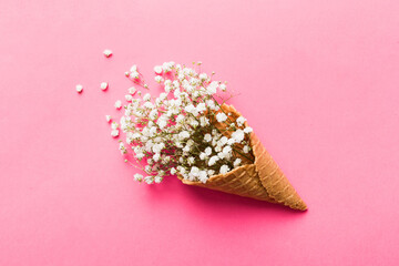 Waffle cone with beautiful gypsophila flowers on color background. summer concept. Copy space top view
