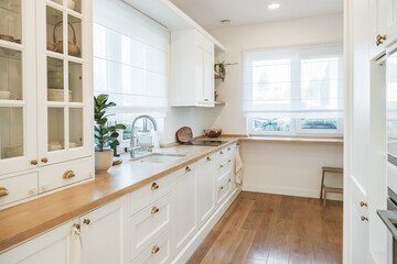 Fototapeta na wymiar Beautiful bright spacious white kitchen made in classic style