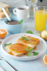 Sandwiches with marmalade, orange juice and coffee ready for breakfast	