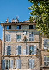 A beautiful residential neighbourhood with a classic, sun clock-decorated building in Aix-en-Provence. Its architectural facade is an iconic symbol of the city.