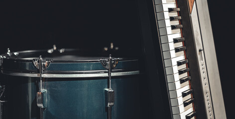 Obraz premium Drum and musical keys on a black background, close up.