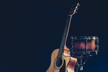 Acoustic guitar and snare drum on a black background isolated. - obrazy, fototapety, plakaty