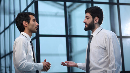 Two businessmen discussing in a meeting in a modern office