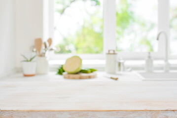 Wooden cooking table top on blurred kitchen window light background