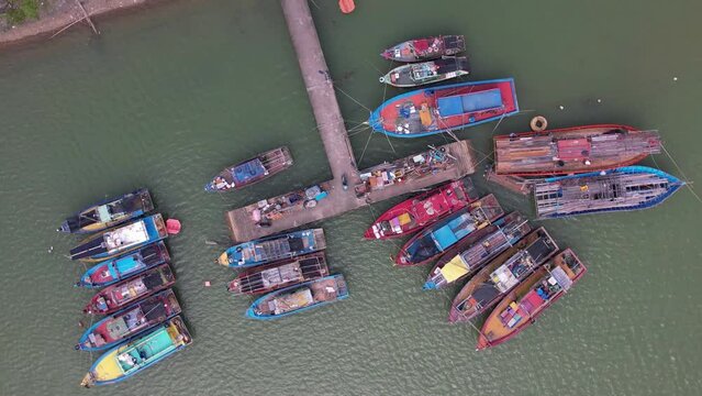 Aerial circle zoom out, traditional colorful Asian fisherman boats in Besut, Terengganu, Malaysia. 4K