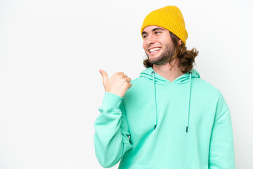 Young handsome man isolated on white chroma background pointing to the side to present a product