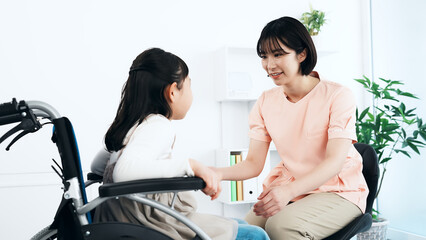 車椅子に乗った女の子を診察する看護師　医師