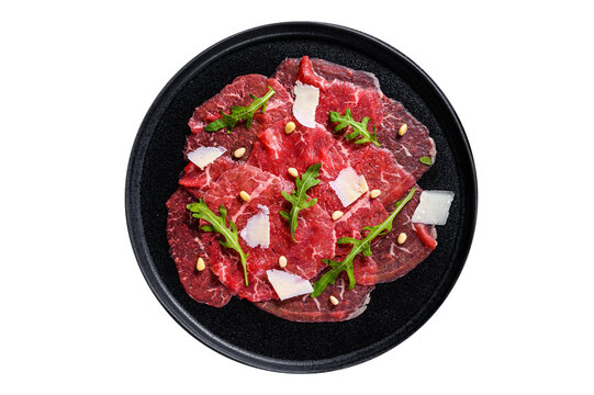 Beef carpaccio on black plate with parmesan sauce, cheese and arugula.  Isolated, transparent background