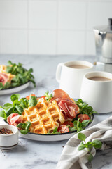 Cheesy belgian waffles served with ham, tomatoes and lettuce corn on white marble background with text space. Savory waffles. Healthy breakfast