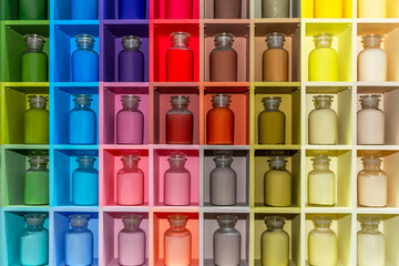 Pallet with glass jars of multi-colored paints on the shelves. Art, hobby and creativity. Close-up. Front view.