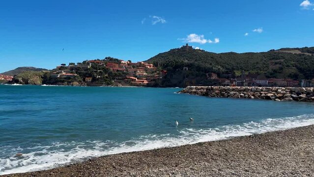 Tourists relax in the beach in the small village of Colliure, France.