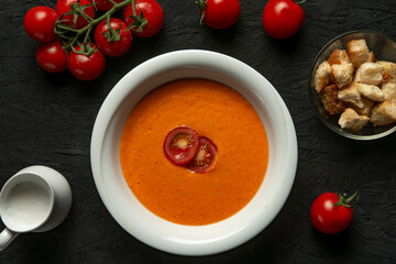 tomato cream soup in white bowl on black desk