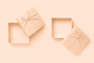 Open beige square gift box with a bow