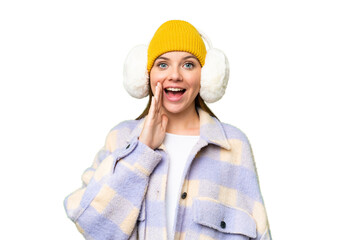 Young blonde woman wearing winter muffs over isolated chroma key background with surprise and...
