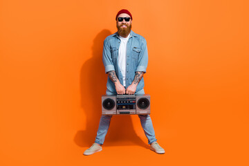 Full size photo of positive guy holding boom box enjoy music occasion isolated on vivid color background