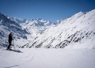Fototapeta na wymiar young man with ski makes pose in mountains behind