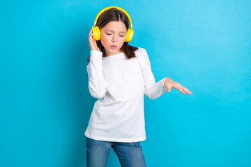 Photo of funny cool little girl wear white shirt having fun dancing listening music earphones isolated blue color background