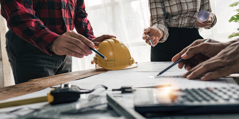 Civil engineer teams meeting working together wear worker helmets hardhat on construction site in modern city. Foreman industry project manager engineer teamwork. Asian industry professional team.