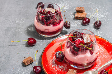 Delicious Italian dessert panna cotta with sweet cherry sauce, fresh berries and chocolate