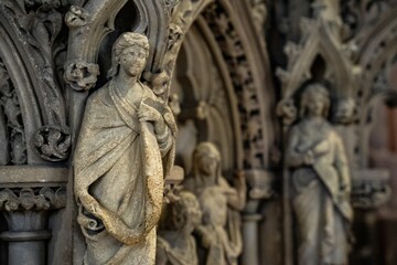 Selective focus of a gothic sculpture on the buildings exterior wall.