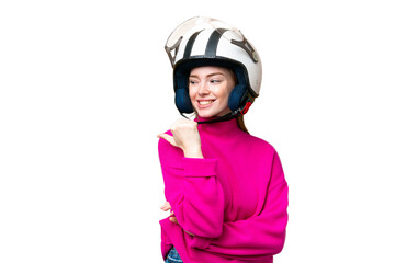 Young pretty woman with a motorcycle helmet over isolated chroma key background pointing to the side to present a product