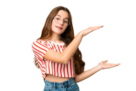 Teenager girl over isolated chroma key background holding copyspace to insert an ad