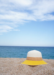 A hat in the sand on the beach with copy space in the sky. Summer holidays