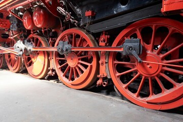 Closeup of red steam wheels on a locomotive