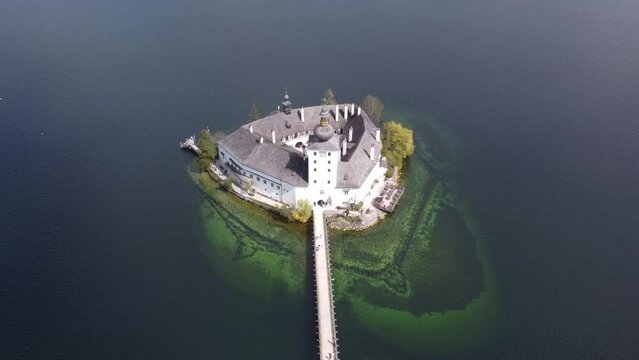 Backwards flight over the Schloss Ort and the Landschloss in Gmunden at lake Traunsee in Upper Austria