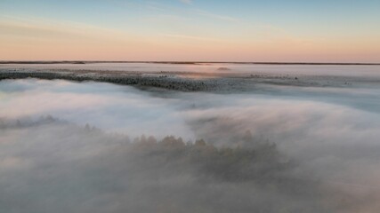 Obraz premium Beautiful view of a lake with a cloudy sky and little morning mist