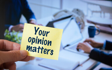 Male hand holding sticky note written Your opinion matters.
