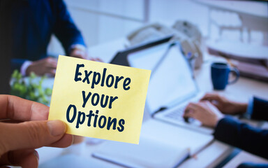 Male hand holding sticky note written Explore Your Options.