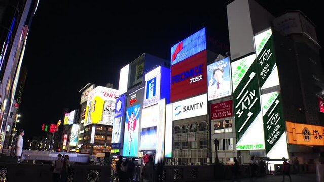 OSAKA, JAPAN : View of Dotonbori at night. Tourist destinations, filled with neon signs, clubs, bars and restaurants. All the logo and signs are blurred or overwritten for this video. Time lapse shot.